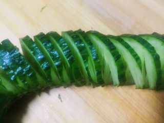 9、#吉祥年夜菜#青龙送福~蓑衣黄瓜,切完后整条黄瓜不断开，如图这样很有收缩性，像拉花一样