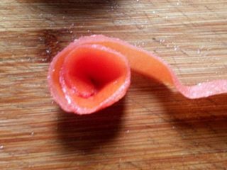 3、#百搭西红柿# 番茄玫瑰花,将整条番茄皮，外皮朝内从一头开始卷起