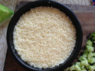 1、焗饭（米饭披萨）,米饭用鸡蛋液拌匀放入烤盘。