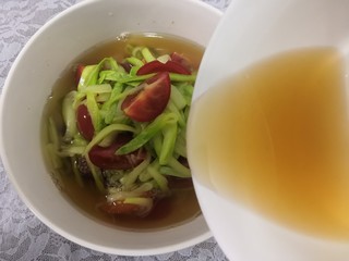 14、小番茄生瓜捞,把准备好的料汁，倒入番茄生瓜丝中