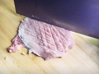 2、黄金猪排,切半厘米厚的大片,用刀拍松再用刀背轻轻敲开一些。