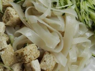 6、自制凉皮,把凉皮切成宽度适中的长条, 放入面筋, 黄瓜丝混在一起，放盐, 蒜泥, 生抽, 辣椒油拌一下即可