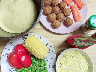 5、黑椒牛肉披萨,准备好食材，玉米、红椒、青豆、牛肉丸、蟹肉棒、芝士碎、番茄沙司、披萨草、和好的面。