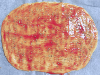 9、黑椒牛肉披萨,在饼上刷一层番茄沙司，撒上一层披萨草。