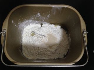 1、肉松面包卷,将液体原料、白糖、奶粉、放入面包机桶底部上面加入面粉、酵母启动和面程序20分钟