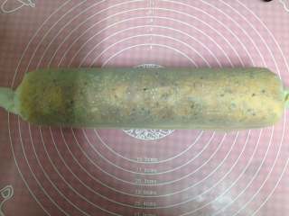 7、肉松面包卷,借助下面的油纸和擀面杖把面包片卷起，要卷紧一些。油纸两头扭紧，静置半小时定型