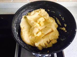 5、原味绿豆冰糕,炒到水份蒸发一些,豆泥比较干时,加入第一次的黄油,翻炒到黄油全部融合到豆泥中