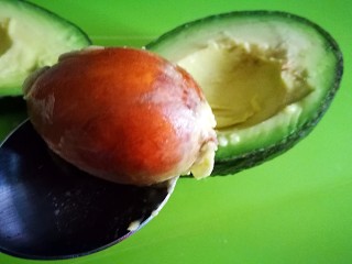 10、百变鸡蛋～牛油果焗蛋,用勺子将核取出