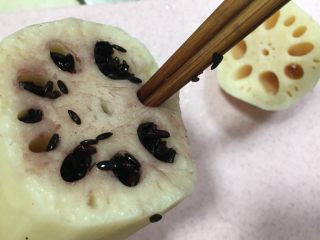 7、紫米糖藕,用筷子将紫米塞入莲藕孔中，用筷子压实。