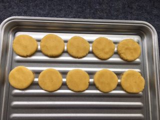 12、花生芝麻小酥饼,摆在烤盘上，用手稍稍压扁。（因为家里没有油纸，直接放烤盘上了，有油纸可以先垫上油纸，再放饼干面团）