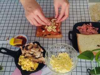 6、培根吐司比萨,取一半的奶酪丝，均匀撒在两片吐司面包上。