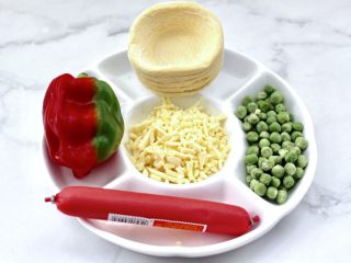 1、蛋挞火腿时蔬小披萨,首先备齐所有的食材，把蛋挞皮提前拿出来解冻。