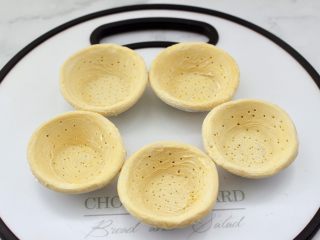 5、蛋挞火腿时蔬小披萨,解冻后的蛋挞皮用竹签扎一些孔。