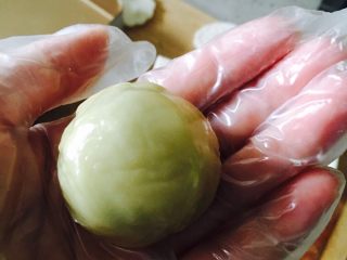 23、广式红豆沙蛋黄月饼,将饼皮放在左手虎口位置，放入红豆沙蛋黄馅，用右手按压内馅儿，左手一边转一边收拢饼皮，收拢口用手将收口处按紧。