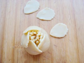 7、#甜味#花好月圆创意月饼,围绕着花蕊面团，一片压住另一片的三分之一处，粘贴住。