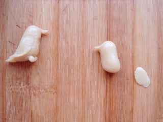 17、#甜味#花好月圆创意月饼,一端捏出尖尖的嘴巴，再捏小小的椭圆形面片做翅膀。