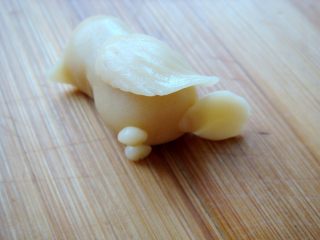 18、#甜味#花好月圆创意月饼,粘贴上小面片，用竹签压出羽毛的纹路。捏水滴状面片，粘贴住做尾巴。搓两个小圆球面团沾贴上，做小脚。