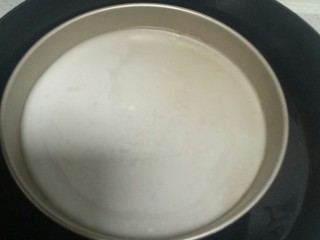 26、自制凉皮,锅中放入适量水，水开后转中火，披萨盘中盛入1勺搅拌均匀的面汁，放入锅中。