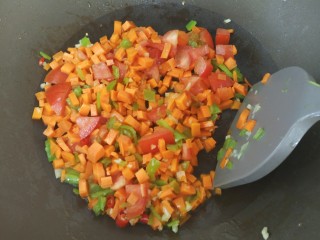 4、家常意面,倒入胡萝卜丁、番茄丁和火腿丁爆炒2分钟