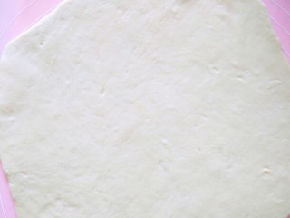 11、超长拉丝批萨,取面团出来，排气，再擀平，擀成和批萨盆一样大小，不要擀太厚也不要太薄了，大概两个硬币厚就行了。