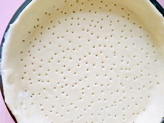 12、超长拉丝批萨,再放进批萨盆里，底部用叉子扎孔，以免烤的时候有气泡会鼓起来，再去除多余的边沿