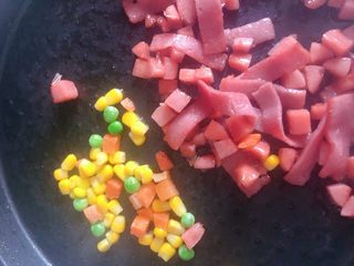 2、培根火腿披萨,锅中放入适量的黄油 煸炒培根 香肠 和蔬菜粒