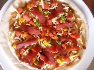7、培根火腿披萨,摆放上香肠粒 培根和蔬菜粒再铺上一层马苏里拉