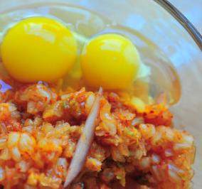 2、韩式泡菜芝士饼,辣白菜沥干水分切成碎丁放入容器，打入鸡蛋，放入香葱碎和洋葱丝