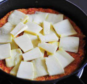 5、韩式泡菜芝士饼,不停转动锅子，使煎饼能完全活动不粘锅，翻面放上切好的芝士。