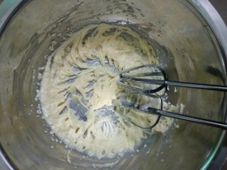 3、纽扣饼干,用打蛋器打发至体积蓬松，黄油颜色变浅。