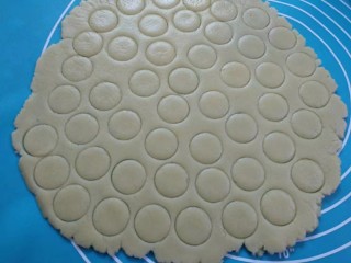 8、纽扣饼干,将面团放硅胶垫上用擀面杖擀成薄片，用大号裱花嘴刻出圆形。