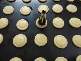 10、纽扣饼干,再用小一圈的裱花嘴在圆形中间刻出一个浅点的圆圈印子。