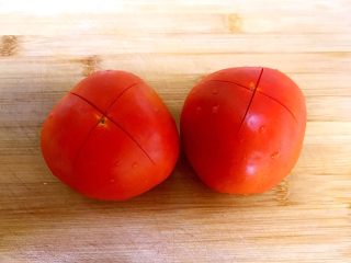 2、自制披萨酱,在西红柿上面切个十字