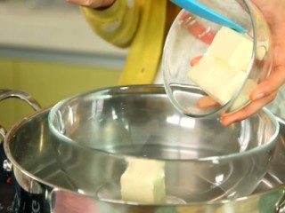 6、草莓芝士慕斯,奶油芝士隔水软化，然后用电动打蛋器搅打至顺滑，记得把溅起的芝士也刮进去