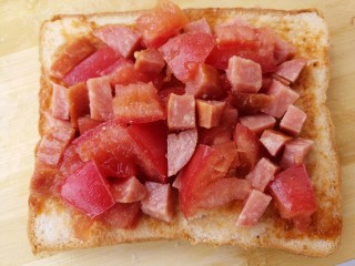 8、玉米粒香肠芝士烤土司,然后把西红柿和香肠放上去