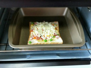 9、做年货+快手吐司披萨-田园风光,再撒上一层芝士,入烤箱中层,180度烤10分钟即可。