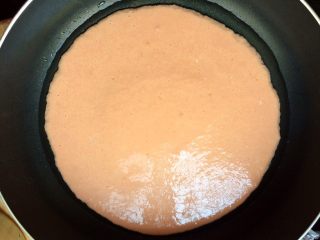 14、百变鸡蛋＋星星番茄鸡蛋饼,平底锅刷适量油，倒入面糊，轻轻晃动锅子，摊成圆形饼，小火煎