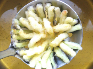 5、酸甜菊花茄子,将茄花放在小漏勺上，另一只勺子舀油浇在茄花上定型后，入油锅炸到外皮酥脆金黄