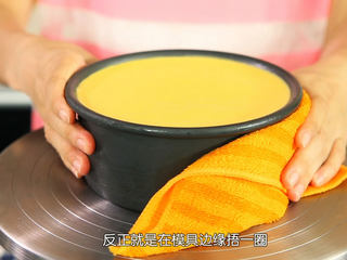 13、芒果流心慕斯,把已经冷藏好的芒果流心慕斯用热毛巾捂一下外围融化，方便脱模，撕开底部油纸，移到碟子上