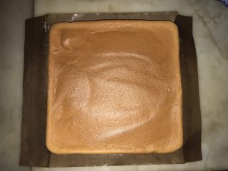 10、紫菜肉松蛋糕卷（烫面戚风）#家有烤箱#,出炉将烤盘连蛋糕从高处摔一下，移至烤网，将蛋糕四边油纸揭开，晾至还有余温