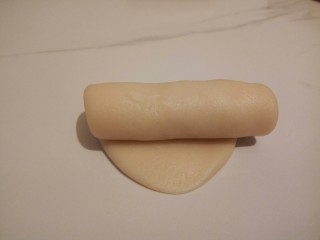 8、#甜味#凤梨蛋黄酥, 从上至下卷起，每卷好一个都要用保鲜膜盖好，继续醒10分钟，然后再从之前第一个擀好的进行