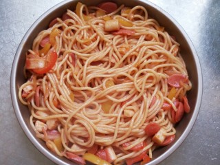 15、简易芝士焗意面,把炒好的面均匀的放入披萨盘里