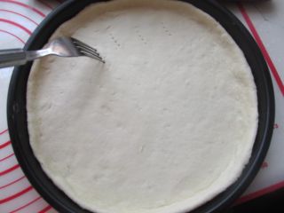 8、鸡肉秋葵披萨,铺到披萨盘中，用叉子插上孔。