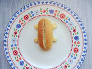 15、小热狗造型面包,在上部的中间切一条开口，不要切透，留出放香肠和生菜叶的空间即可