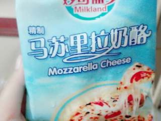 5、果蔬披萨,奶酪稍微软化，刨子削丝。均匀的撒在布满番茄酱和千岛酱的披萨上，然后加入准备好的材料，在材料上加多一层奶酪丝