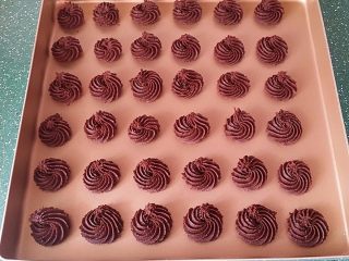 8、巧克力曲奇,手握裱花袋在金盘中均匀挤出曲奇坯