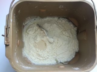 1、鸡肉蔬菜披萨,将披萨皮的所有材料放入面包桶里，酵母放在最上面，面粉挖个洞放入酵母再用面粉盖住