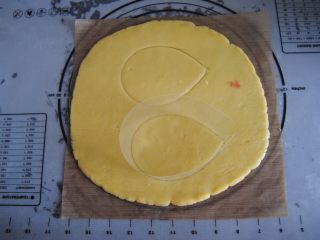 5、花环糖霜饼干,取出用擀面杖擀成0.5cm高度的面片，用慕斯圈模具印出椭圆形