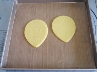 6、花环糖霜饼干,冷藏变硬后取出放入烤盘内，用叉子扎几排洞