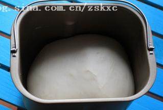 4、北极虾培根肉酱比萨,盖上保鲜膜，启用烤箱发酵功能，时间设置为60分钟，发酵好的面团是原来的2.5倍大